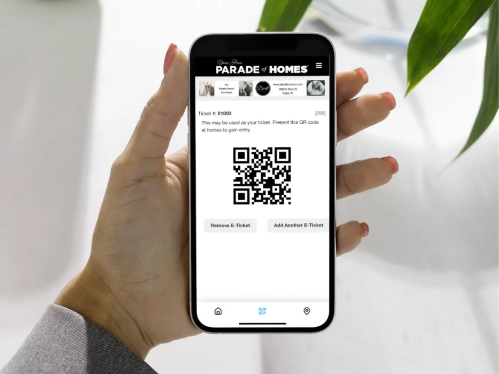 Holding a phone with a digital e-ticket that is transforming parade of homes